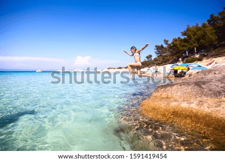 Fun on the summer vacation. Child jumping in the sea. Beautiful seascape