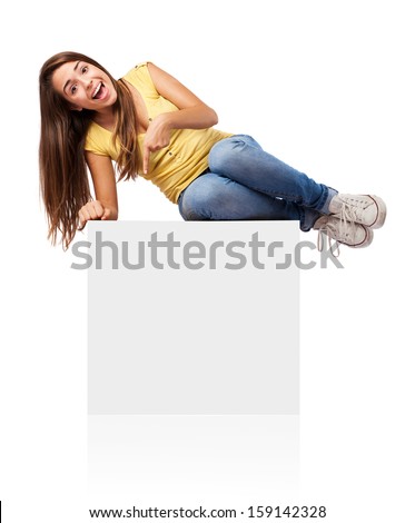 Woman sitting on blank empty box, pointing down at copy space.