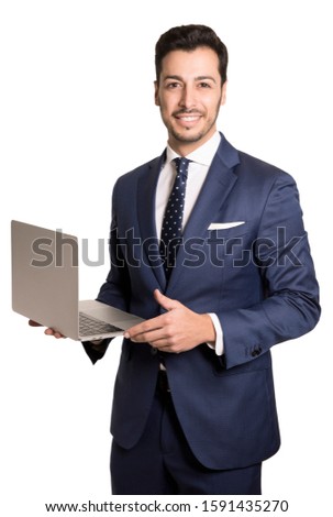 Confident business expert. Confident young handsome man in blue suit and tie holding open grey laptop and smiling while standing against white background