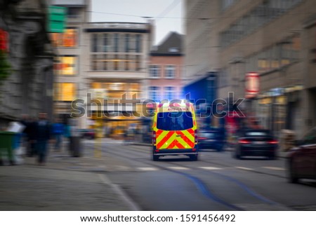 Back view of emergency ambulance car in a blurred street Royalty-Free Stock Photo #1591456492