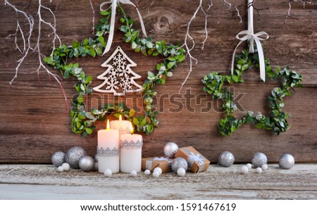 Christmas composition with candles and festive decorations on a wooden background. Christmas or New Year greeting card.