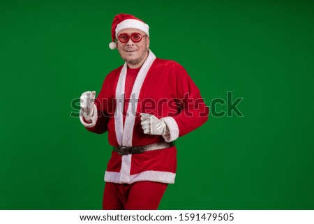 Emotional Santa Claus in pink glasses dances and gestures on a dark red background