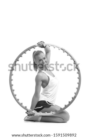 young sporty woman with hula hoop on a white background