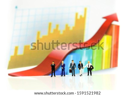 Miniature people : Successful businessman with Paper graph chart ,Business Growth concept.