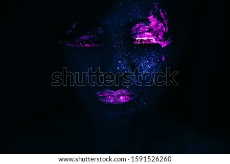 Portrait of Beautiful Fashion Woman in Neon UF Light. Model Girl with Fluorescent Creative Psychedelic MakeUp, Art Design of Female Model in UV, Colorful Abstract Make-Up