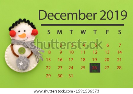 Kwanzaa (Umoja means Unity) December 2019 Calendar Snowman wearing ear muffs, scarf and mittens green background