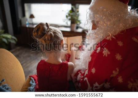 Santa Claus asks a girl a New Year picture. New Year