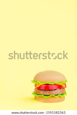 fast food. plastic hamburger on a yellow background
