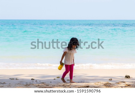 ฺBaby girl walk on the beach at Andaman sea.