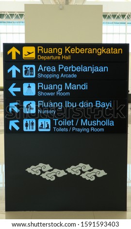 Departure hall, shopping arcade, shower room, nursery, toilets and praying room information board sign in airport.