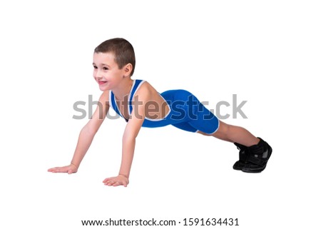 Portrait of a little cheerful boy in a blue wrestling tights and p stands on his hands in a push-up pose, looks forward and poses on a white isolated background. concept of a little fighter athlete