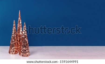Futuristic  sparkling copper golden Christmas trees on white and classic blue background. Holiday backdrop concept. Banner wide screen format, place for text