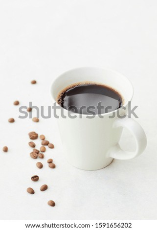 A cuop of coffee and coffee beans on white background. Royalty-Free Stock Photo #1591656202