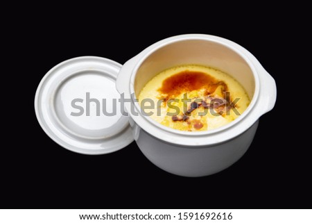 Photo taken of a chicken cake in a ceramic stew pot on a black background.