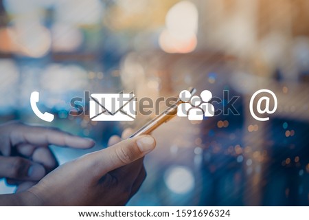 Contact us or Customer support hotline people connect. Businessman using a mobile phone with the (email, call phone, mail) icons. Royalty-Free Stock Photo #1591696324