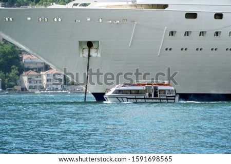  A small pleasure boat on the background of a large cruise liner.                              