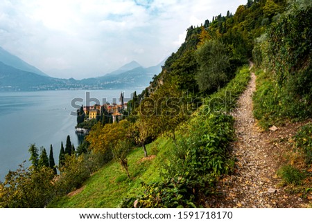 Trail in the mountains of lake Como, Italy. With Varenna and the lake far in the background.