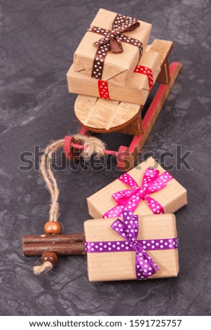 Wrapped gifts with red ribbon for Christmas time or other occasion and wooden sled