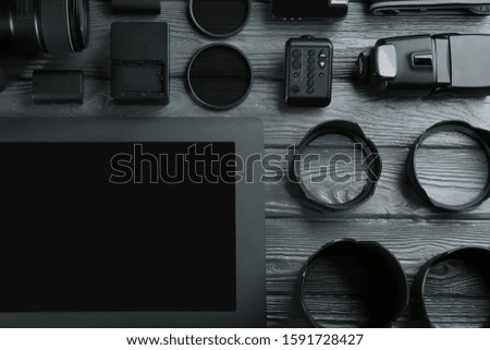 Flat lay composition with equipment for professional photographer on grey wooden table