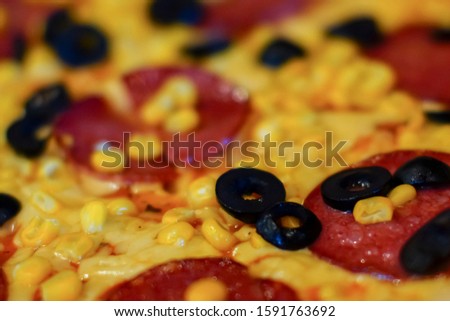Delicious fresh pizza with meat, tomatoes and mushrooms served on a board on dark wooden table, close up