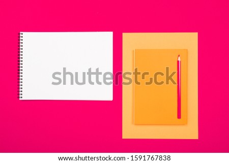 School and office supplies lie neatly on a pink background