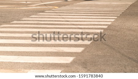 crosswalk on the road for safety when people walking cross the street, Pedestrian crossing on a repaired asphalt road, Zebra crossing on the street for safety, logistic import export and transport.