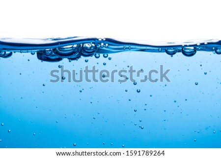 The water surface is clean, blue in color, underwater with small bubbles and a white background as an art form. Royalty-Free Stock Photo #1591789264