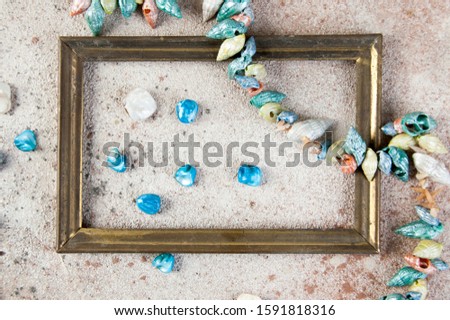 Antique brass empty picture frame and seashells on concrete background. Photography props and copy space for text.  