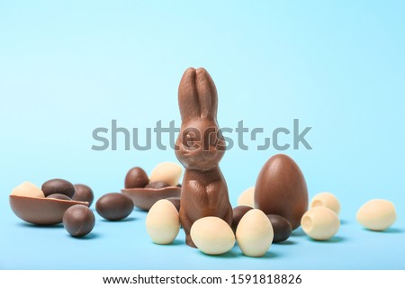 Chocolate Easter eggs and bunny on color background Royalty-Free Stock Photo #1591818826
