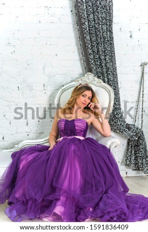 Magical night, blonde hair middle age woman in purple color of evening chiffon dress	