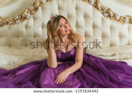 Magical night, blonde hair middle age woman in purple color of evening chiffon dress	