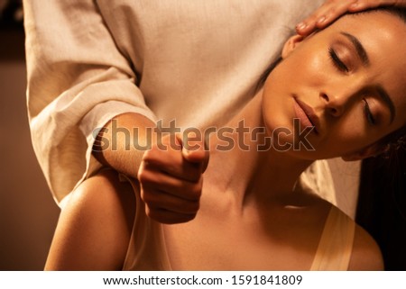 Young pretty woman has Thai massage. Close up of neck stretching. Concept of serene spa treatments. Royalty-Free Stock Photo #1591841809