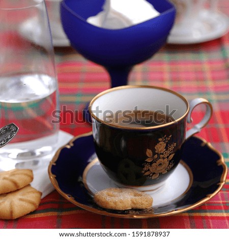 Ice cream in blue glass cup, coffee cup and clean water glass on the table
