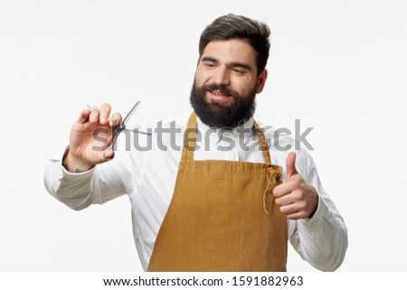 hairdresser in white shirt beige apron and scissors Professional