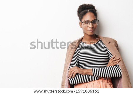 Portrait of african american cute woman in eyeglasses posing with hands crossed isolated over white background