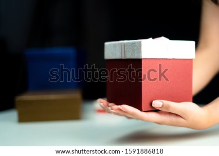 Women hands holding a gift box, birthday or New Year eve celebrating concept.