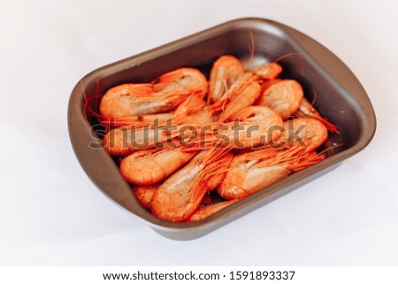 Bowl of fresh shrimp on white background