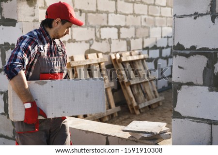 Professional bricklayer is working at the construction site