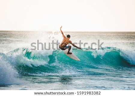 professional surfer riding waves in Dreamland Beach, Bali, Indonesia. men catching waves in ocean. Tail slide water surf, action water board sport Royalty-Free Stock Photo #1591983382