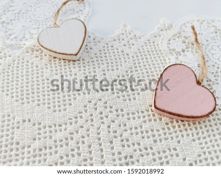 Two heart shaped wooden decorations on a white knitted background. Greeting card. Valentine's day concept. Copy space. 