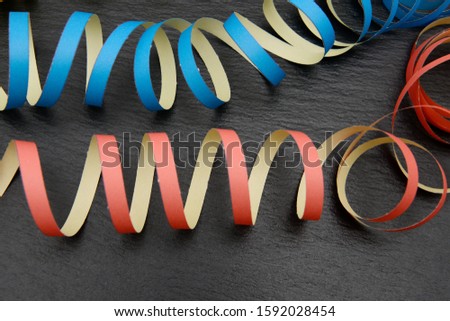 colorful streamer lying on black shale, whether new year's eve or carnival, it is always the right decoration