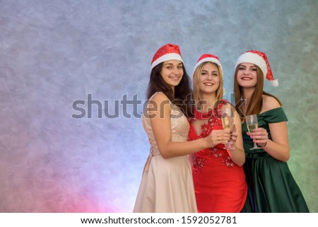"New Year" celebration. Three beautiful woman in evening dresses with champagne glasses