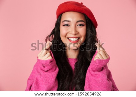 Image of happy beautiful asian girl showing money counting gesture with fingers isolated over pink background