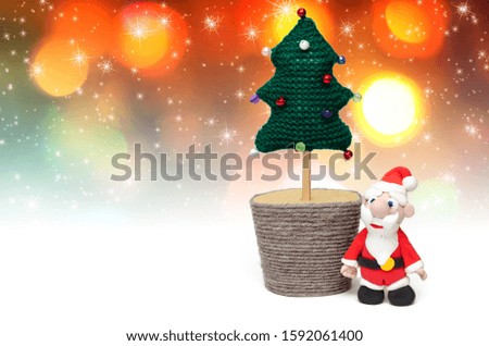 Christmas card. Handmade Santa Claus and knitted Christmas tree on festive background. DIY concept. Copy space