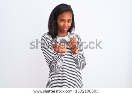Beautiful young african american woman wearing winter sweater over isolated background Ready to fight with fist defense gesture, angry and upset face, afraid of problem