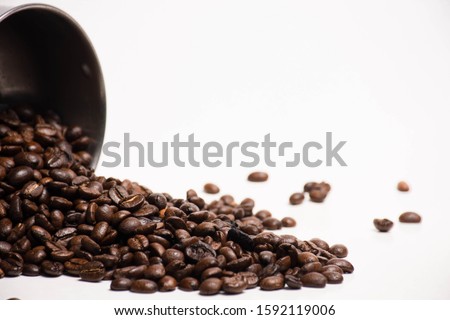 Stainless steel mugs and roasted coffee beans Pour on the white background
