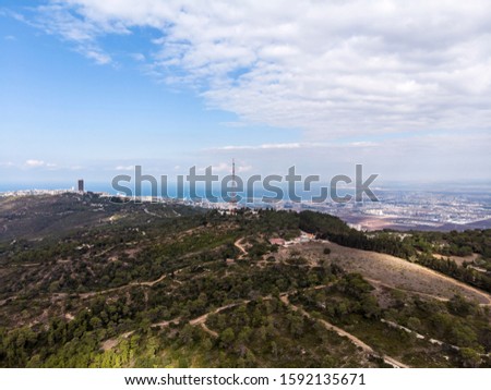 The slopes of Mount Carmel are not foreground. Haifa city and Haifa Bay in the background. Videography from a drone.