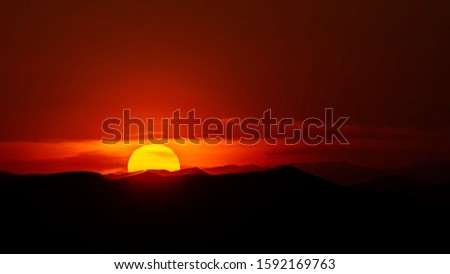 the big sunsets behind the sand dunes in dasht e lut desert with red sky and silhouette foreground