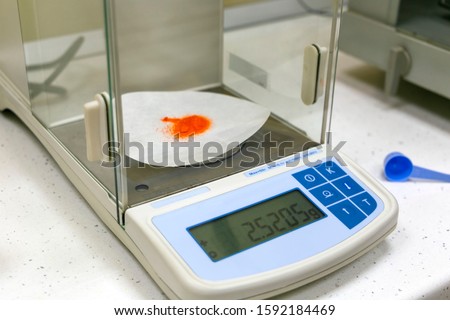 Precise reagent weighing on electronic laboratory balance. Laboratory equipment for chemistry, medicine, pharmacology, microbiology. Royalty-Free Stock Photo #1592184469
