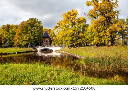 Autumn park, the Slavyanka river and the Pil-tower bridge. Pavlovsk. St. Petersburg. Russia